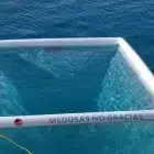 Anti Jellyfish Pool in blue sea. Pool tied to boat.