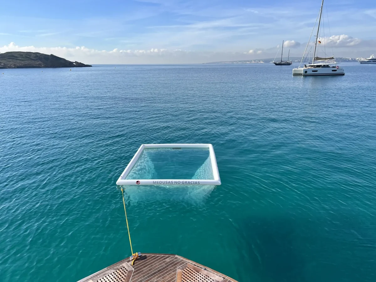 Piscina Anti Medusa en el mar azul. Piscina blanca atada a un barco